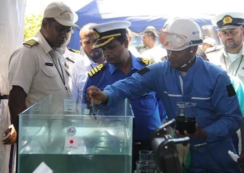 slcg-oil-spill-response-unit-putting-a-sample-of-oil-in-water-tank_-simulating-oil-leak